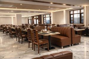 a dining room with tables and chairs in a room at The Indies 365 Hotel in Bangalore
