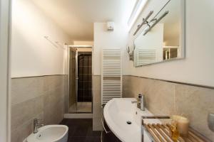a bathroom with a sink and a toilet and a mirror at Il NIDO-Attico Siena Centro con vista Duomo e Torre Del Mangia in Siena +5 photos