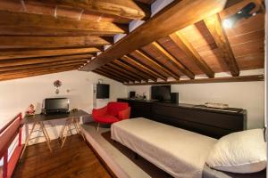 a bedroom with a bed and a desk and a tv at Il NIDO-Attico Siena Centro con vista Duomo e Torre Del Mangia in Siena