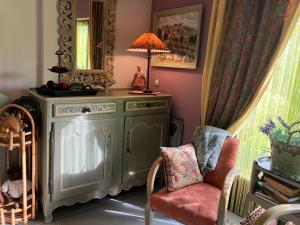 a living room with a chair and a mirror at Une amazone en Provence in Paradou +1 photo