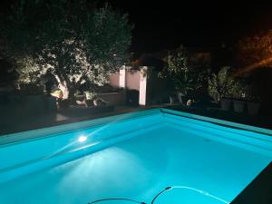 a swimming pool at night with blue lights at Une amazone en Provence in Paradou