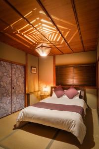 a bedroom with a large bed with pink pillows at Chikyuutabikazoku USJ Ⅱ in Osaka