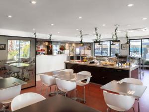 a restaurant with tables and chairs and a bar at ibis Newcastle in Newcastle
