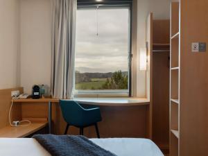 a room with a bed and a desk and a window at Ibis Barcelona Mollet in Mollet del Vallès +193 photos