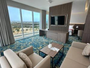 a living room with a couch and a tv at Sur Grand Hotel in Sur