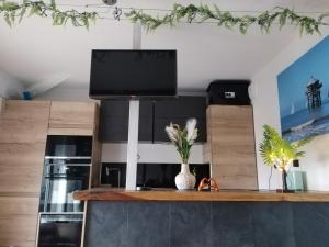 a living room with a flat screen tv on a shelf at Grand studio cosy et lumineux in La Rochelle