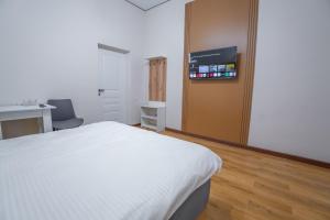 a bedroom with a bed and a desk and a tv at Nura Hotel in Shymkent