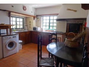 a kitchen with a table and a washing machine at New Village in Vila Nova da Baronia