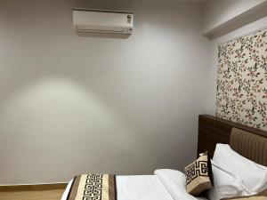 a bedroom with a bed with a air conditioner on the wall at STARLIT Hotel, Ajmer in Madār