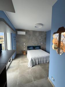 a bedroom with a bed and a blue wall at Il Cubo di Anja Home of amazing view in Pisogne