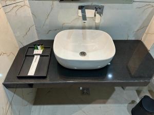 a white sink on a black counter in a bathroom at STARLIT Hotel, Ajmer in Madār