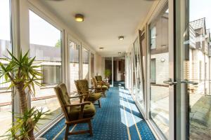 an office corridor with chairs and windows at Hotel Brügge in Ibbenbüren