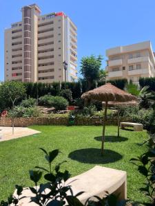 a large umbrella in a park with tall buildings at Bright Flat 1 min from Beach with parking in Fuengirola