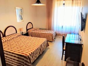 a hotel room with two beds and a window at Balletti Palace Hotel in Viterbo +13 photos