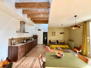 a kitchen and living room with a green table and chairs at L’appartement 39 in Lons-le-Saunier +8 photos
