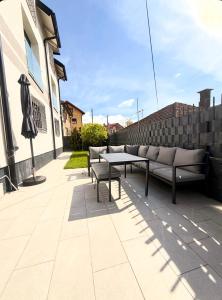 a patio with two benches and a table and an umbrella at Apartment Mey in Sarajevo