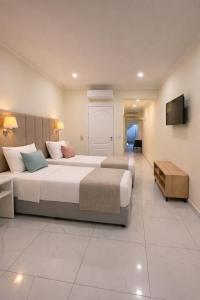 a large bedroom with two beds and a television at Salinas Hotel in Gümbet +14 photos