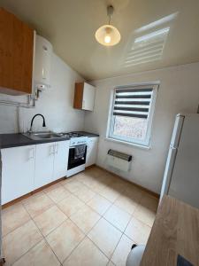 a kitchen with white cabinets and a sink and a window at Apartments center - Затишні апартаменти в центрі біля ЦУМа in Poltava