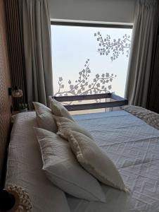 a bed with white pillows in front of a window at Apartamento rural Rubí in El Torno +36 photos