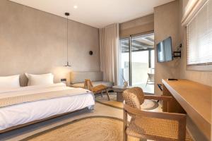 a hotel room with a bed and a desk and chair at Beau Rivage Suites in Lóngos