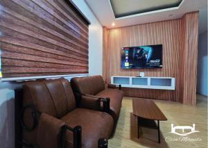 a waiting room with two chairs and a flat screen tv at Casa-Miranda Homestay in Daet