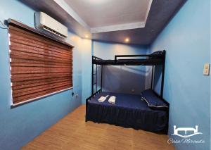 a bedroom with a bunk bed in a blue wall at Casa-Miranda Homestay in Daet