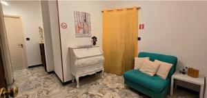 a living room with a green chair and a dresser at Ettorina in Cogoleto