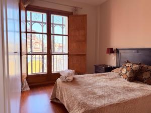a bedroom with a bed and a large window at Smartmonki Sinagoga entre la Catedral y Zocodover in Toledo