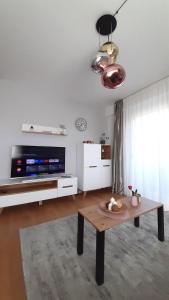 a living room with a table and a tv at Rio Vita with garage parking in Rijeka
