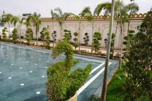 a courtyard of a building with a pool and palm trees at Neendar Heritage Resort in Jaipur