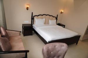a bedroom with a bed and a chair and a couch at Neendar Heritage Resort in Jaipur +78 photos
