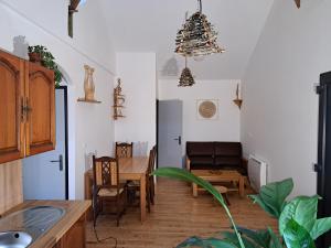 a kitchen and dining room with a table and a chandelier at L'Isba in Saint-Appolinaire