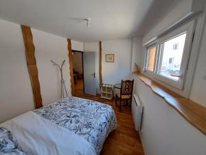 a bedroom with a bed and a window at L'Isba in Saint-Appolinaire