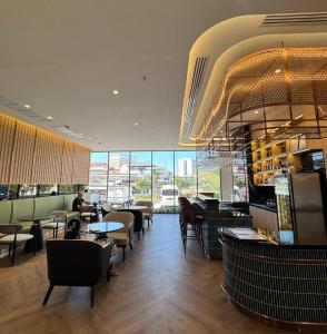 a restaurant with tables and chairs and a bar at Samsara Hotel Pattaya in Pattaya South
