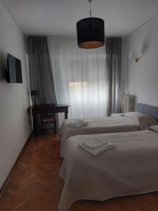 a hotel room with two beds and a desk at Splendid Lido in Venice-Lido