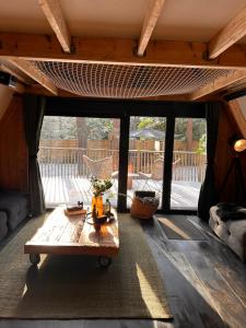a living room with a wooden table and glass doors at Het Dubbele Punthuisje in Lanaken
