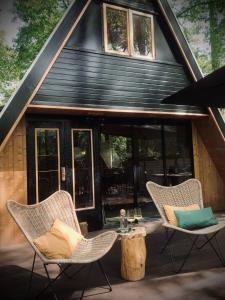 two chairs and a table in front of a cabin at Het Dubbele Punthuisje in Lanaken