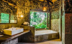 a bathroom with a tub and a sink and a window at Urvinkaan - An Estate Hotel Chikmagalur in Chikmagalur