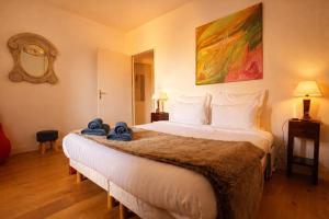a hotel room with a large bed with towels on it at La Salamandre - Un écrin médiéval pour vos souvenirs - Imaginez-vous, réveillé par le murmure de Sarlat, dans un appartement spacieux et chaleureux, au cœur de la Cité classée - 2 chambres - Une magie à vivre sans modération - Réservez dès maintenant ! in Sarlat-la-Canéda
