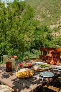 a wooden table with plates of food on it at koman_lakeview_apartments in Shkodër