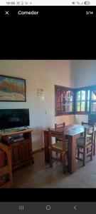 a living room with a table and chairs and a television at cabaña La Retama in Villa Yacanto +12 photos