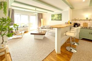 a living room with a kitchen and a living room with a table at Zach Waldglück in Groß Klessow