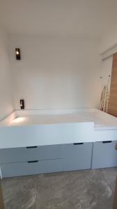 a white bed in a room with a white wall at Salsa Studio terrasse & parking à 100m des plages Juan-les-Pins in Juan-les-Pins +15 photos