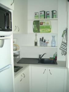 a kitchen with a sink and a microwave at Arcachon Plage Pereire in Arcachon +4 photos