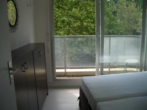 a bedroom with a bed and a large window at Arcachon Plage Pereire in Arcachon
