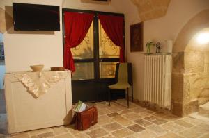 Zimmer mit einem TV, einem Stuhl und einem Fenster in der Unterkunft Antro delle Muse in Altamura