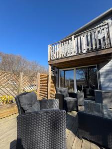 a patio with wicker chairs and a deck with a balcony at TinyHouze in Karlskrona