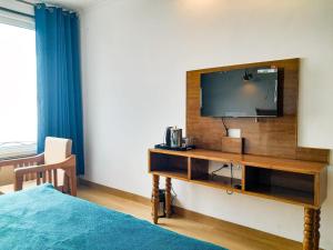 a hotel room with a television and a bed at The Three Oaks Boutique Hotel in Mussoorie