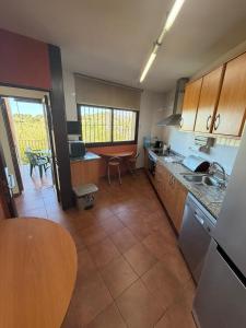 a kitchen with a counter and a table in it at Cal Isabel in Pobla de Montornés +14 photos