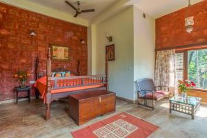 a bedroom with a bed and a red brick wall at Urvinkaan - An Estate Hotel Chikmagalur in Chikmagalur